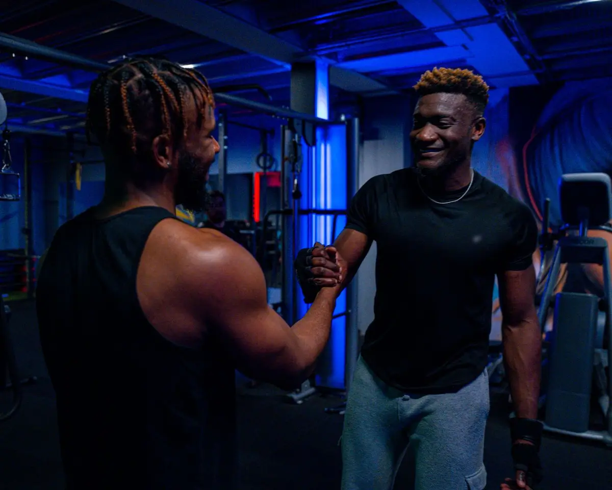 Two gym members smiling and shaking hands